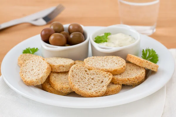 Toasts with olives and sauce — Stock Photo, Image