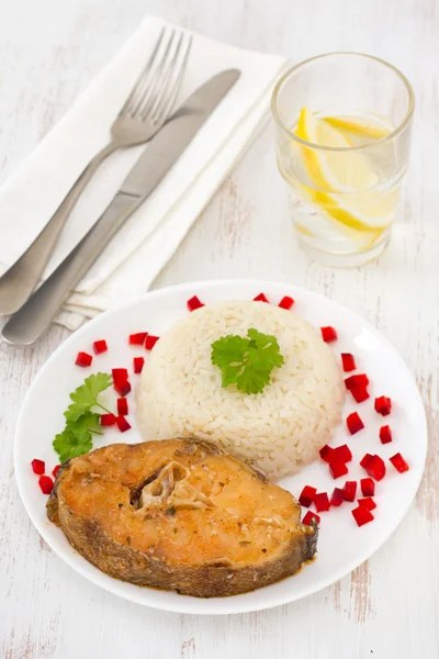 Рыба с вареным рисом на белой тарелке — стоковое фото