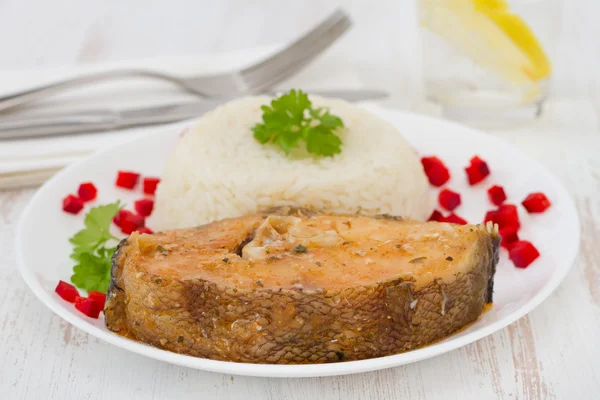 Риба з вареним рисом на білій тарілці — стокове фото