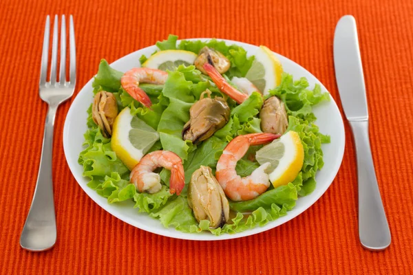 Салат с креветками и мидиями на тарелке — стоковое фото