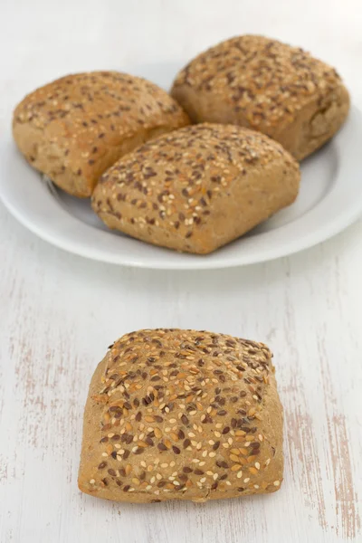 Bröd med spannmål på den vita plattan — Stockfoto