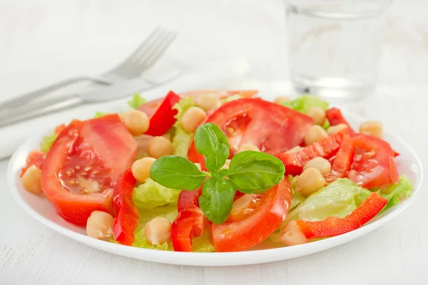 Salad with chickpea and glass of water — Stock Photo, Image