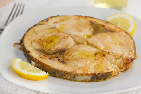 Жареная рыба-меч с лимоном на белой тарелке — стоковое фото