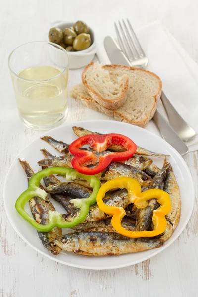 Smažené sardinky s pepřem a sklenicí vína — Stock fotografie