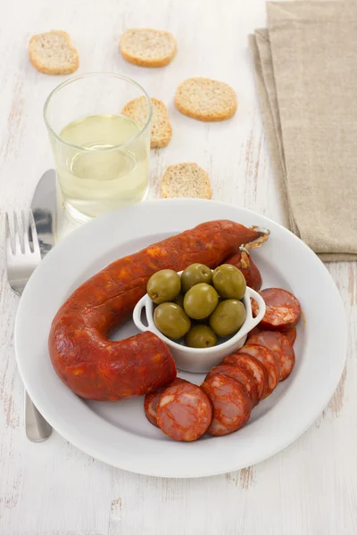Сосиски с оливками на белой тарелке — стоковое фото