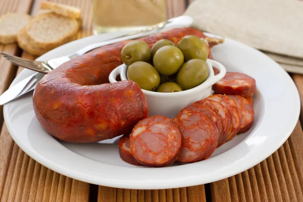Sausages with olives on the white plate — Stock Photo, Image