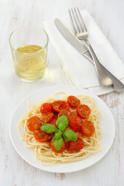 Спагетти с помидорами и соусом на тарелке — стоковое фото