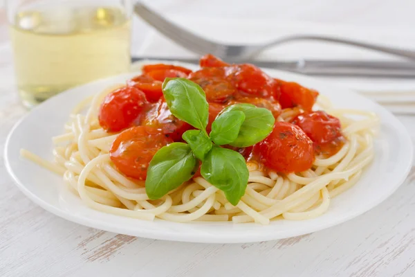 Спагетти с помидорами и соусом на тарелке — стоковое фото
