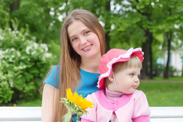 Kleines Mädchen und junge Mutter in einem Park — Stockfoto