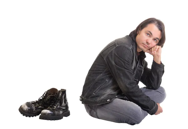 Junger, lässiger Mann sitzt auf dem Boden, isoliert auf weißem Grund — Stockfoto