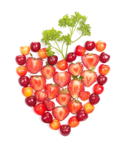Strawberries and cherries with greens in heart shape — Stock Photo, Image