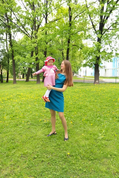 Glad kvinna med ett barn som vilar på natur — Stockfoto