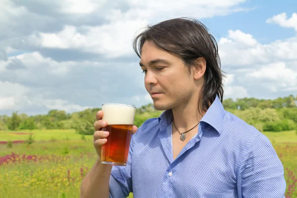 Man with beer in spring meadow — Stock Photo, Image
