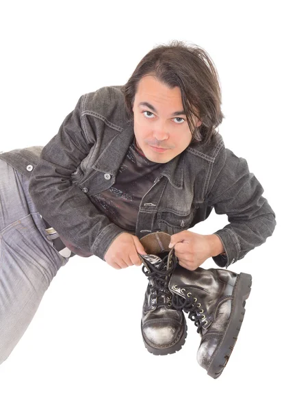 Pohledný muž v džínách oblečení s jeho boty — Stock fotografie