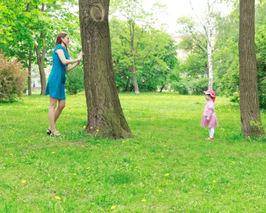 Mother and girl playing hide-and-seek clipart