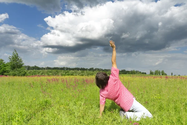 Man with hand up on meadow — Stock Photo, Image