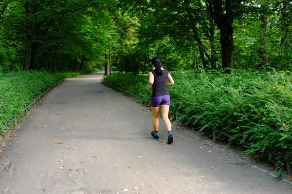 Молодая красивая белая женщина бегает в летнем парке . — стоковое фото