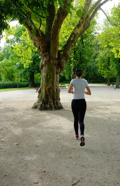 Junge schöne kaukasische Frau joggt im Sommerpark. — Stockfoto
