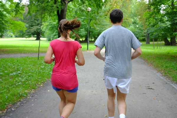 Casal caucasiano correndo no parque de verão . — Fotografia de Stock