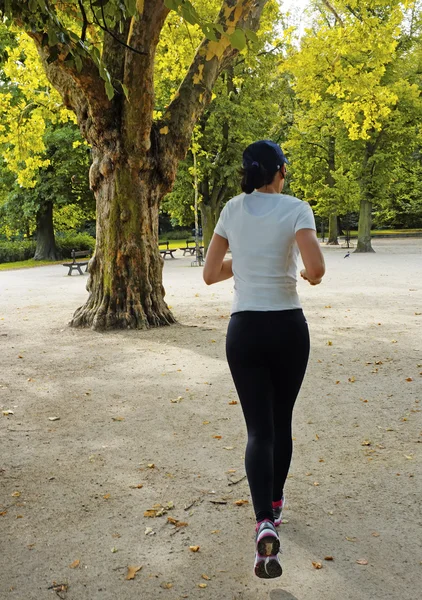 Jonge mooie Kaukasische vrouw joggen in zomer park. — Stockfoto