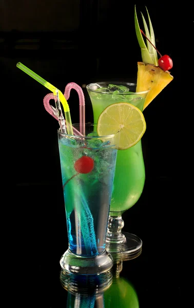 Green cocktail with pineapple and blue cocktail with ice and lim — Stock Photo, Image