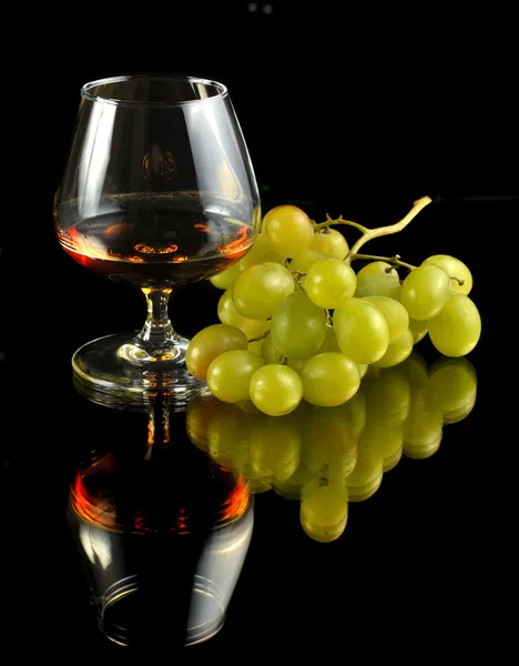 stock image Glass of brandy and grapes