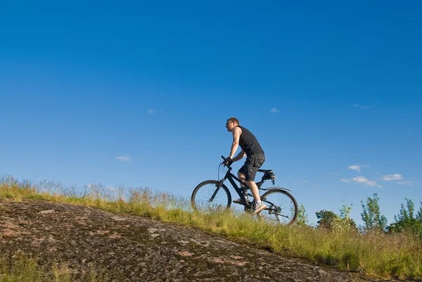 Jovem em uma bicicleta de montanha — Fotografia de Stock