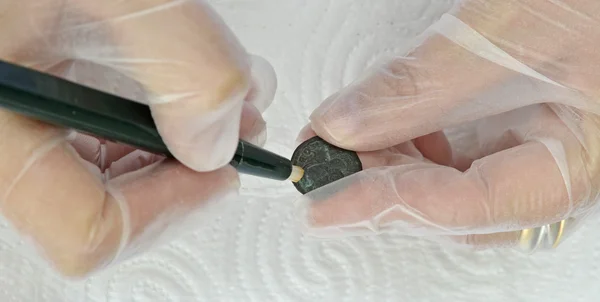 Frau restauriert antike Münzen mit Glasfaser — Stockfoto
