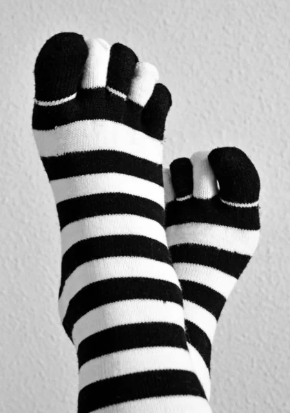 Two feet in stockings black and white striped — Stock Photo, Image