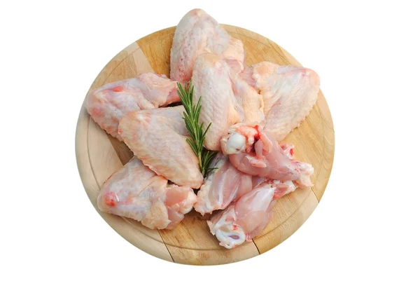 Alitas de pollo en una tabla de cortar de madera aislada en blanco Fotos De Stock