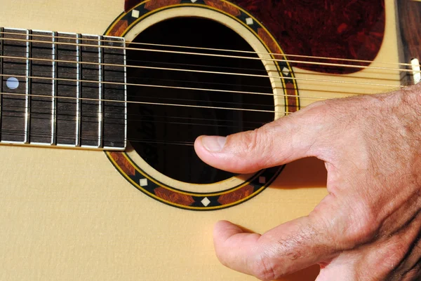 Мужчина вручную играет на акустической двухструнной гитаре — стоковое фото