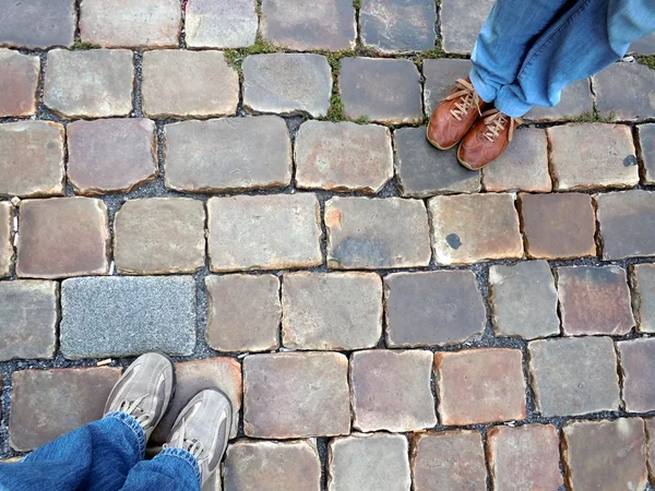 Twee paar schoenen staan over een stenen grond — Stockfoto