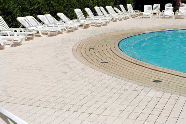 Лимпидный бассейн и белые шезлонги без — стоковое фото