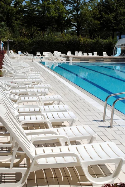 Лимпидный бассейн и белые шезлонги без — стоковое фото