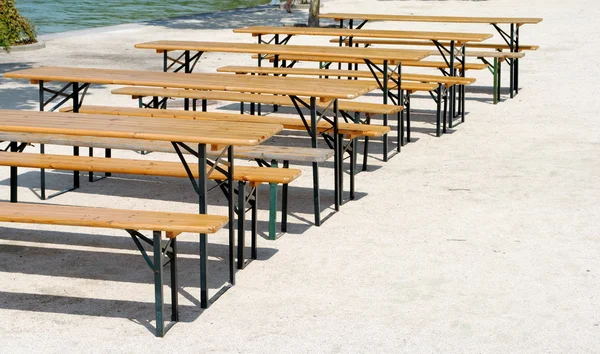 Wooden benches and tables in a row — Stock Photo, Image