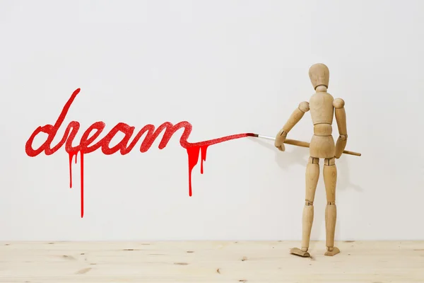 Mannequin writing with a brush the word dream — Stock Photo, Image