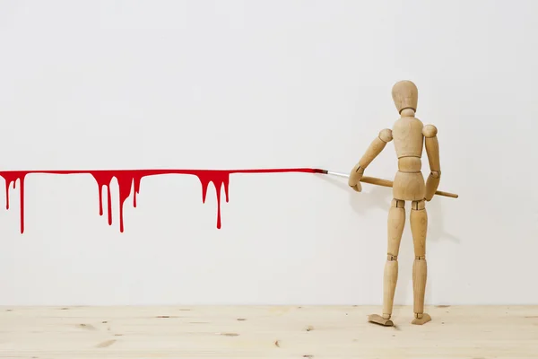 Mannequin writing a red line with a brush — Stock Photo, Image
