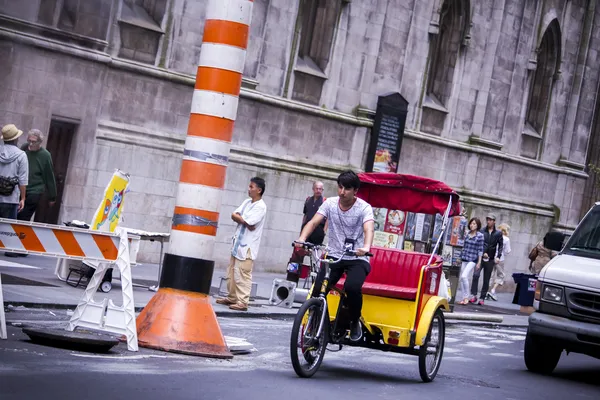 Eine Rikscha im New Yorker Verkehr Stockbild