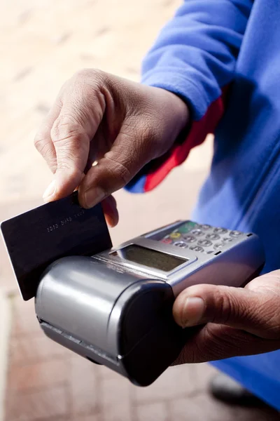 Africano mano deslizando tarjeta de crédito — Foto de Stock