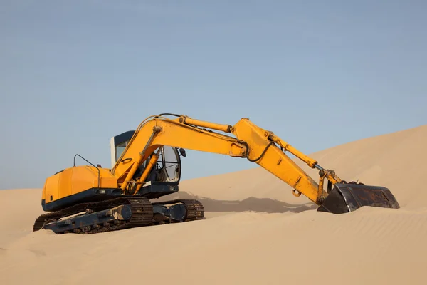Yellow excavator on a sand dune — Stock Photo, Image