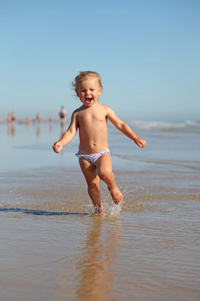 Дитяча дівчинка біжить на пляжі — стокове фото