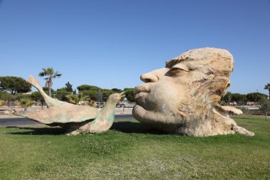 Man kissing a bird - sculpture in Matalascanas, Andalusia Spain clipart