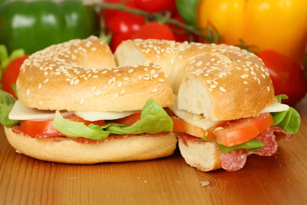 Bagel with salami, tomatoes, cheese and salad — Stock Photo, Image