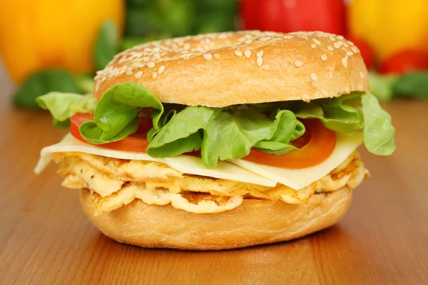 Closeup of a vegetarian bagel with omelet, cheese, tomatoes and salad — Stock Photo, Image