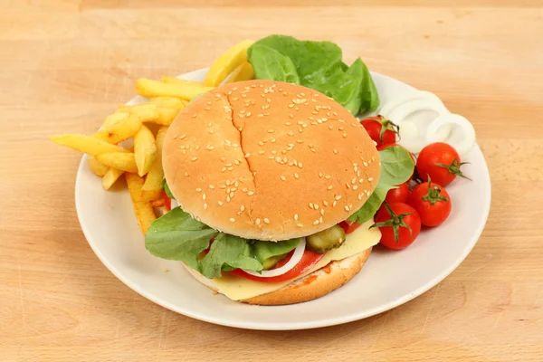 Hambúrguer de queijo saboroso com batatas fritas e tomates — Fotografia de Stock