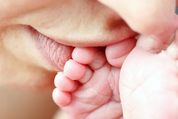 Mother kissing her little newborn baby's feet — Stock Photo, Image
