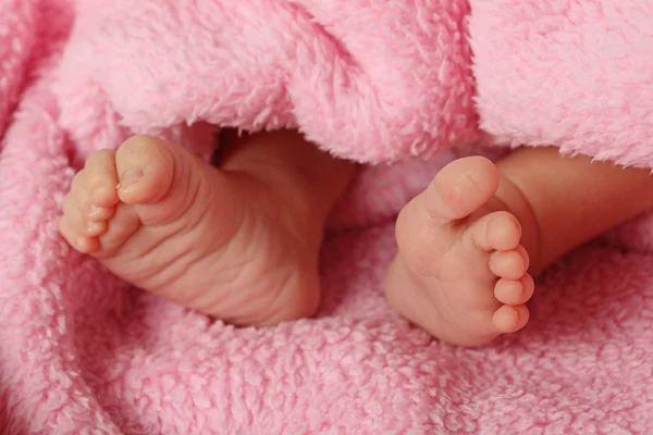 Pequeños pies de un bebé recién nacido — Foto de Stock