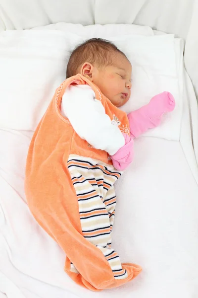 Nyfödd baby flicka sover i sin säng — Stockfoto