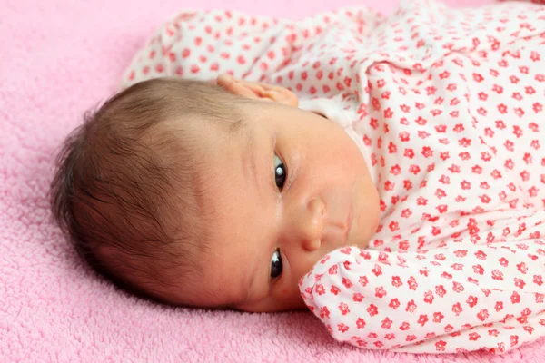 Portrait of a beautiful newborn baby girl on pink blanket — Stock Photo, Image
