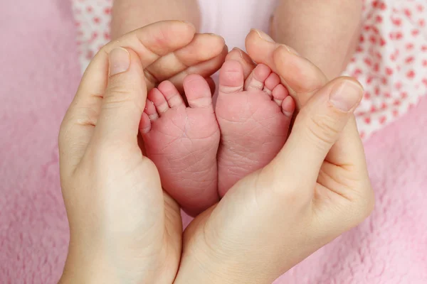 母親の手で生まれたばかりの赤ちゃんの足 — ストック写真